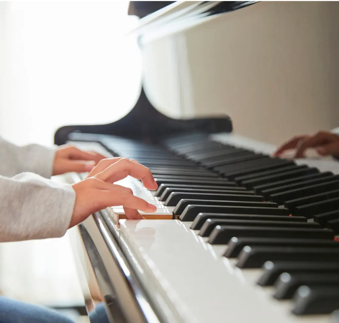 Person playing piano with colorful stage lighting